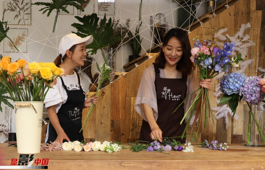 “昆明是鮮花的原產(chǎn)地，有亞洲最大的鮮切花交易市場，可以說具備開花店的天時地利；另外和很多女孩一樣，我從小也就有開花店的夢想！”說起當(dāng)初的決定，王黎媛說一是因?yàn)閴粝?，另外也跟昆明這個城市產(chǎn)花、賣花的“基因”有關(guān)。圖為王黎媛和同事在制作花束。新華網(wǎng) 周亞平/攝 念新洪/文