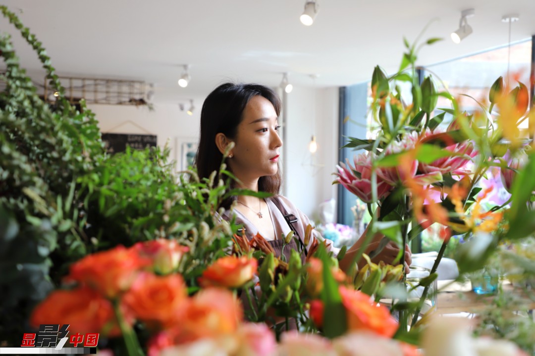 每天和花打交道是一個(gè)幸福的職業(yè)，但同時(shí)也充滿壓力和挑戰(zhàn)，“花在呈現(xiàn)給客人的那一瞬間是美好的，但前面的每一個(gè)步驟都是很辛苦的?！蓖趵桄抡f，花藝是最原始的手工藝產(chǎn)品，沒有辦法機(jī)械化、流程化和規(guī)?；仨氁秒p手一點(diǎn)點(diǎn)地賦予其生命和美感。圖為王黎媛在挑選制作花束的鮮花。新華網(wǎng) 周亞平/攝 念新洪/文